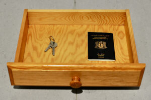 "Der Schlüssel", 2021, Remi Alkhiami. Wooden Drawer, Syrian Passport, keys, Audio in Arabic and German